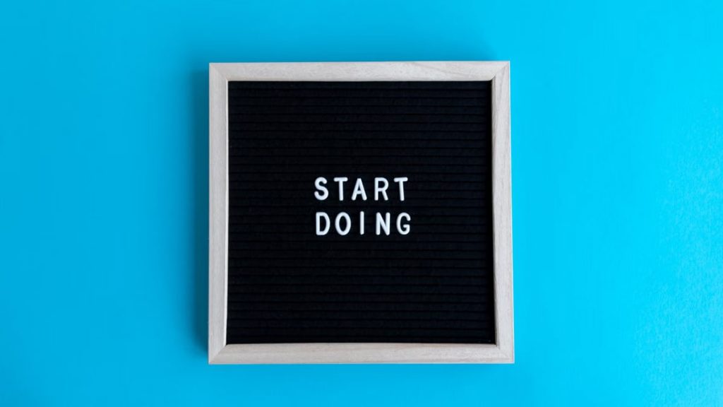 Black letter board with 'START DOING' text on a vibrant blue background.
